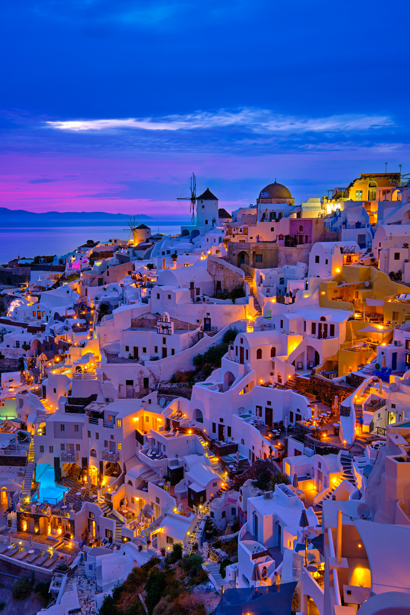 Oia village, windmills, Santorini island, Greece at colorful sunset Greek Background